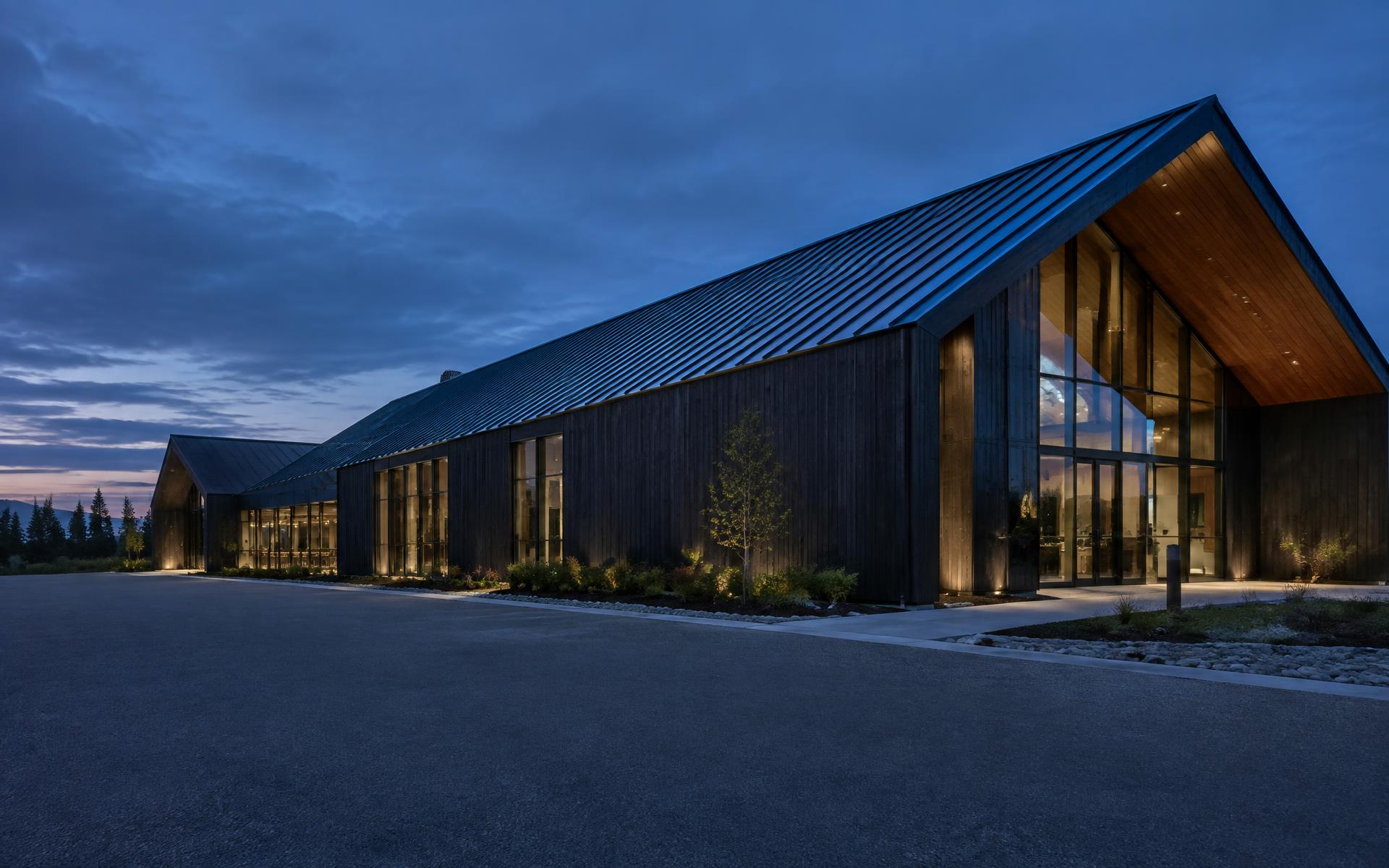 Modern commercial building with metal roof at dusk