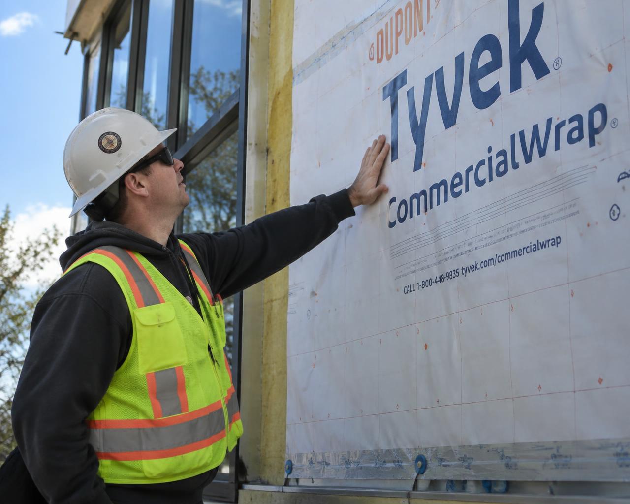 Worker inspecting commercial building wrap